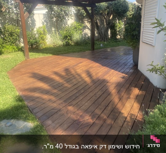 דק עץ בגינה עם פרגולה מעץ מעליו